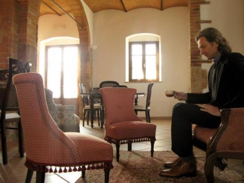 a woman sitting on a chair in a room at Tenuta Il Tresto in Poggibonsi