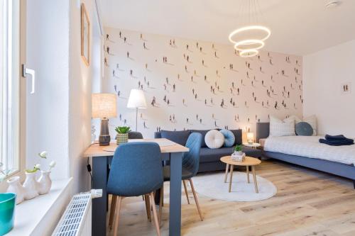 a living room with a blue couch and a table at Stadtoase Chemnitz in Chemnitz