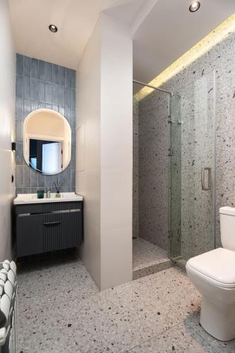 a bathroom with a toilet and a sink and a mirror at Blueloft 52 I Tashkent City Center in Tashkent