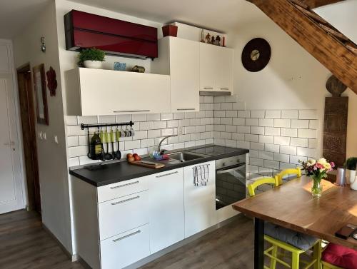 a kitchen with white cabinets and a wooden table at Apartment Luna in Bovec