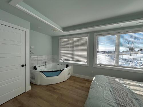 a bathroom with a tub in a room with windows at Cocagne Ocean Suites- Bed & Breakfast in Cocagne 