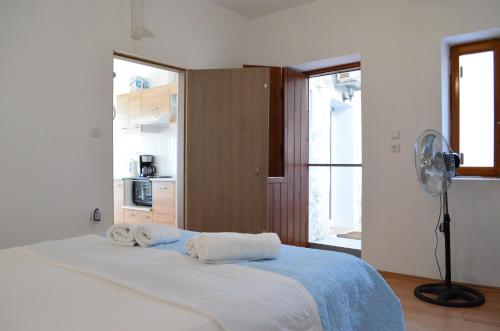 a bedroom with a bed with towels on it at Myrtos Harmony Apartments in Myrtos