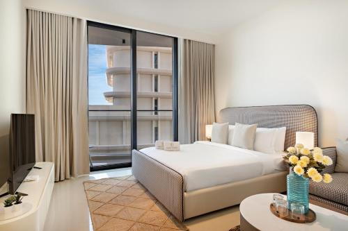 una habitación de hotel con cama y sofá en FIRST CLASS Studio Stunning Beachfront Bliss, en Ras al Khaimah