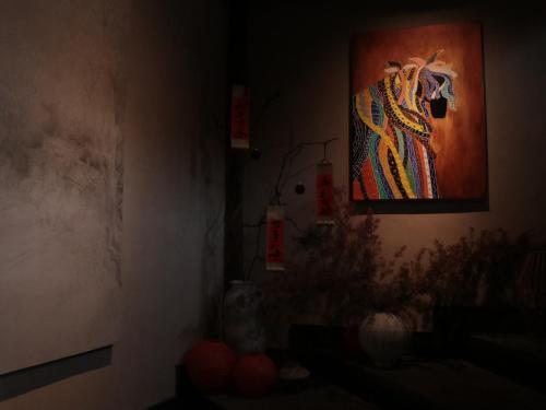 a room with a painting of a horse on the wall at Shishe Spring Designer Homestay in Dujiangyan