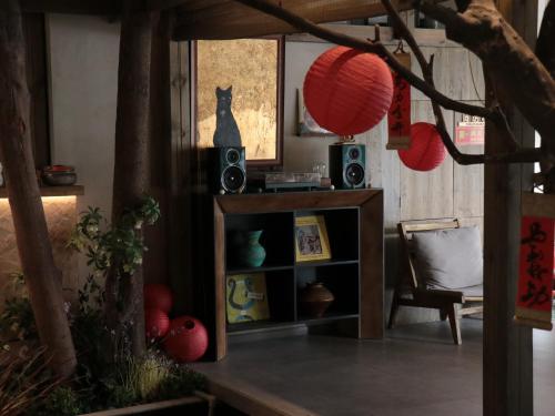 a room with a cat sitting on a shelf with speakers at Shishe Spring Designer Homestay in Dujiangyan