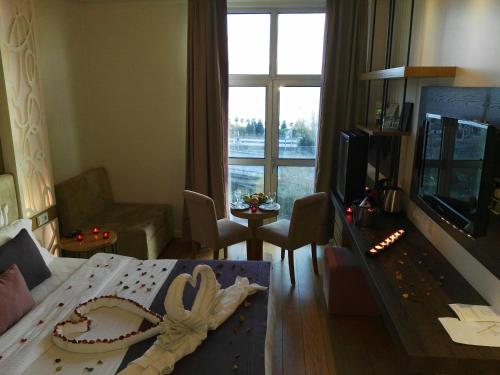 a living room with a bed and a living room with a window at Wes Hotel in Kocaeli