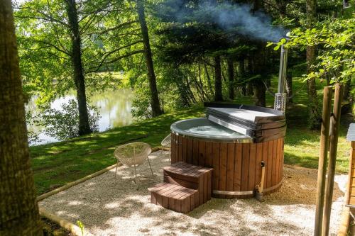 a hot tub with a grill in a park at Chalet et étang, exclusivement privée in Manzat
