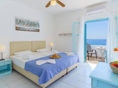 a bedroom with a bed with a view of the ocean at Makrigialos Apartments und Studios in Makry Gialos
