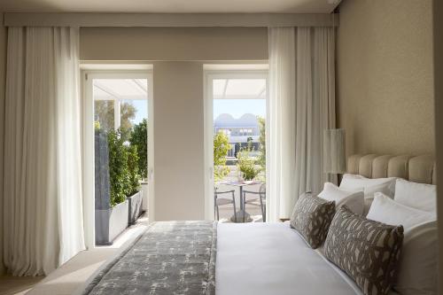 a bedroom with a bed and a view of a patio at Santorini Heart Hotel & Spa in Fira