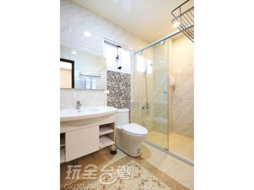 een badkamer met een toilet, een wastafel en een douche bij Fong Sin Zih B&B in Magong