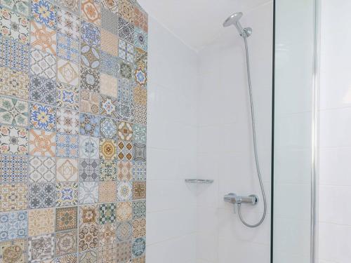 a bathroom with a shower with a tiled wall at Makrigialos Apartments und Studios in Makry Gialos