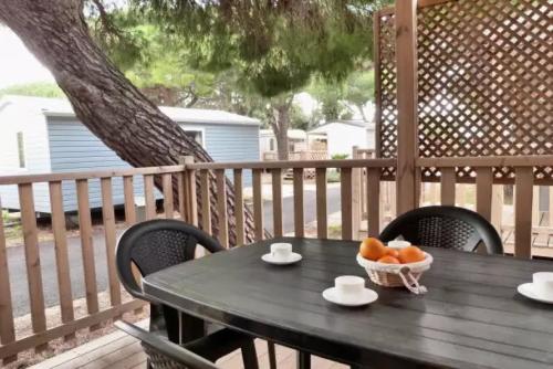 Camping - eebaeb في هييريس: طاولة عليها وعاء فاكهة على سطح خشبي