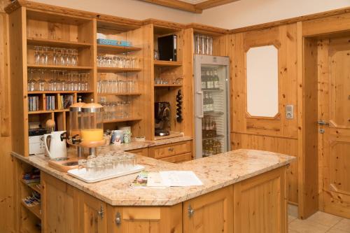 a kitchen with wooden cabinets and a counter top at Hotel Garni Landhaus Platzer in Zell am Ziller