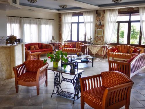 a living room with couches and a table and chairs at Areti Aparthotel in Áptera