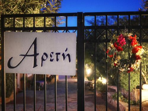 a sign on a gate with a flower wreath at Areti Aparthotel in Áptera