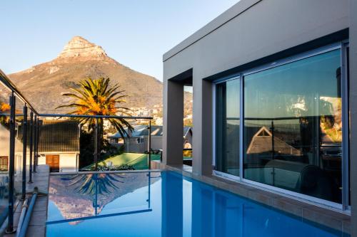 a house with a swimming pool with a mountain in the background at Villa on Slopes of Geneva Drive in Cape Town
