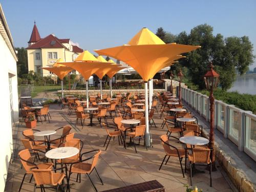 a row of tables and chairs with umbrellas on a patio at Pension Villa Else in Heidenau