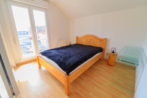 Un dormitorio con una cama y una mesa de cristal. en Isabelle, en Stella-Plage