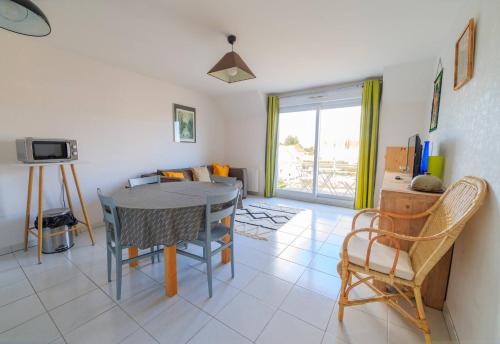 Una cocina y un comedor con mesa y sillas. en Isabelle, en Stella-Plage