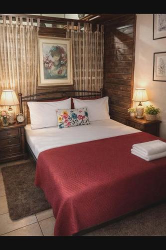 a bedroom with a large bed with a red blanket at green hill studio corfu town in Corfu