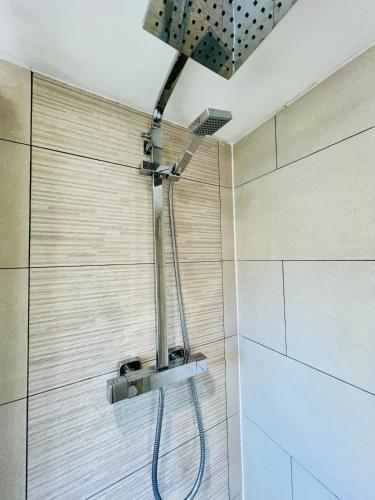 a shower with a shower head in a bathroom at Stylish 3 Bed Apt Sea Views Near the Beach 2B in Felixstowe