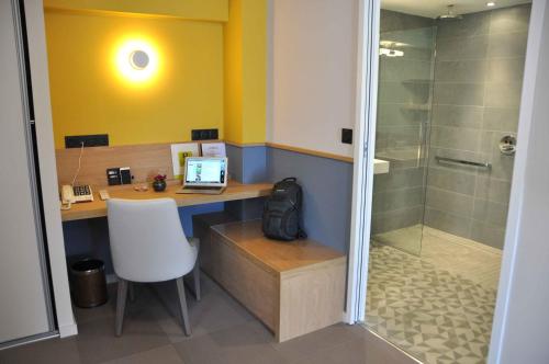 a bathroom with a desk with a computer and a shower at Relais De L'abbaye in Charlieu