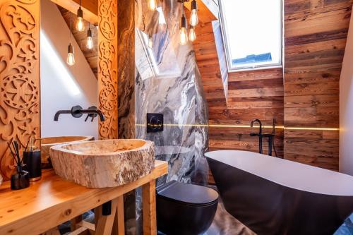 a bathroom with a large stone sink and a tub at Tatra Heaven Residence & Jacuzzi in Kościelisko
