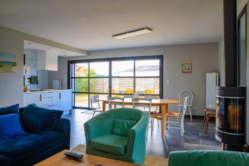 Una sala de estar con un sofá azul y una mesa. en Valentin, en Stella-Plage