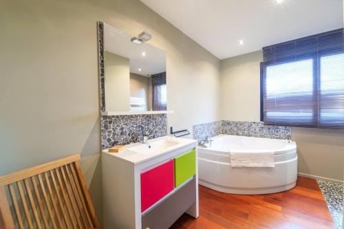 Un baño con bañera, lavabo y bañera. en Valentin, en Stella-Plage