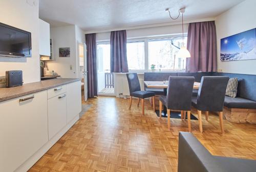 eine Küche und ein Esszimmer mit einem Tisch und Stühlen in der Unterkunft Appartement Relax & Sport in Saalbach-Hinterglemm