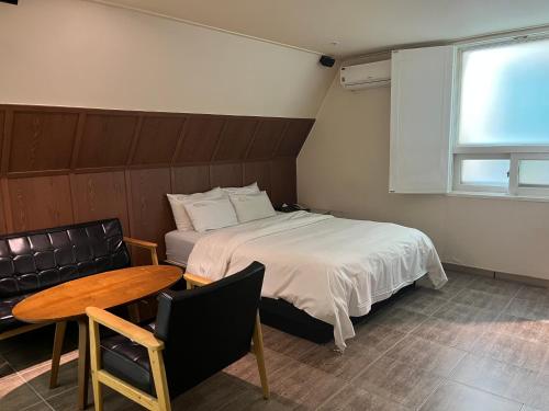 a bedroom with a bed and a table and a chair at Sixty Hotel in Seoul