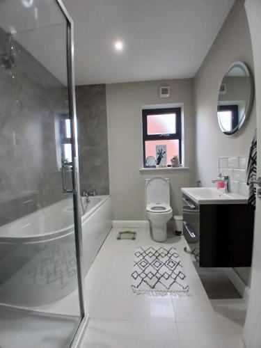 a bathroom with a shower and a toilet and a sink at Private room in shared house at Casa de Charlie in Lambeg