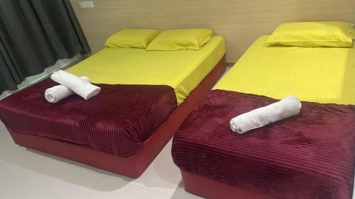 two beds in a room with towels on them at Batu Caves Paradise Hotel in Kuala Lumpur