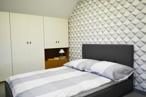 Schlafzimmer mit einem Bett mit einem schwarzen und weißen Kopfteil in der Unterkunft Apartamenty 66 c in Wisła