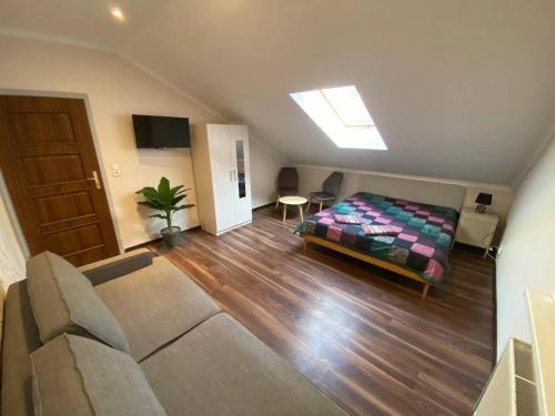 a bedroom with a bed and a couch in a room at Pokoje na wynajem w Willi in Warsaw