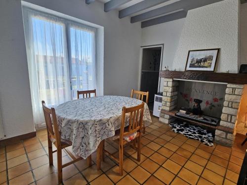 a dining room with a table and a fireplace at "la maison de rolland" in Saint-Martin-lʼArs