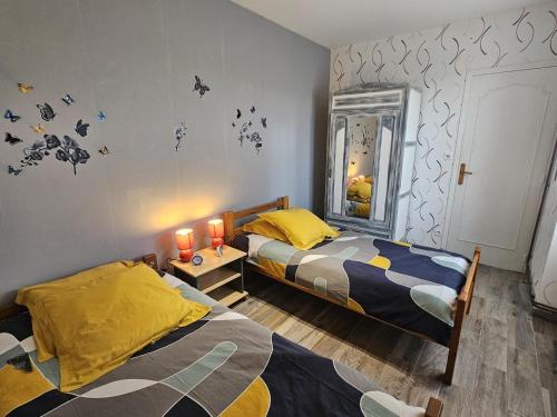 a bedroom with two beds and a mirror at "la maison de rolland" in Saint-Martin-lʼArs