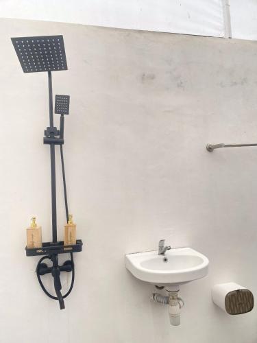 a bathroom with a sink and a solar panel on the wall at Ohara Glamping in Kubupenlokan