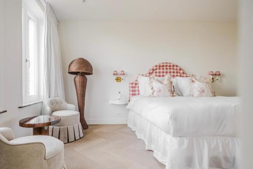 une chambre blanche avec un lit et une chaise dans l'établissement La Villa Rosa, à Bruges