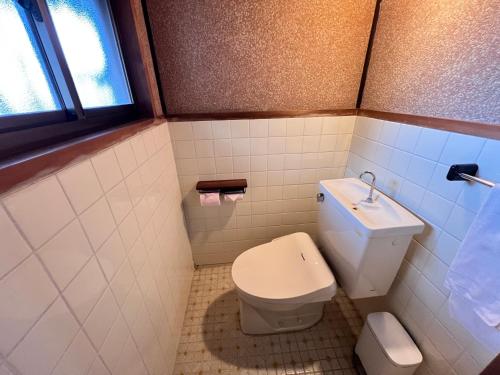 a small bathroom with a toilet and a sink at 瀬戸内海を望む庭付き古民家サウナ宿 一棟貸切 in Takamatsu