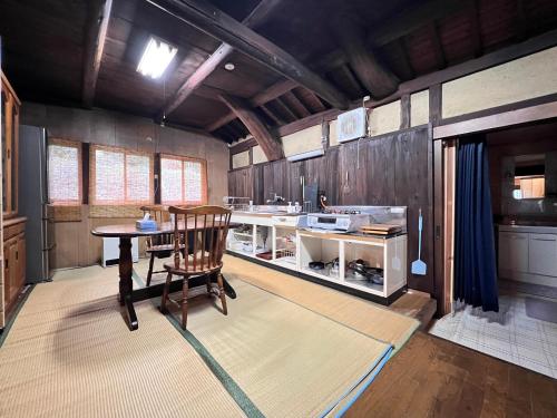 a kitchen with a table and a chair in a room at 屋島 築120年 古民家 1棟貸切 in Takamatsu