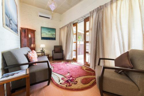a living room with two chairs and a rug at The Ocean Residence Langkawi in Kuah