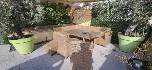 a table and chairs on a patio with plants at Penthouses+Terrasse 60 m2+Box 2 Vehicules in Beausoleil