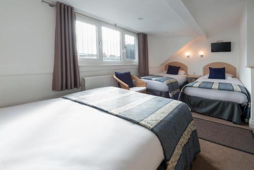 a hotel room with two beds and a tv at The Melita in London
