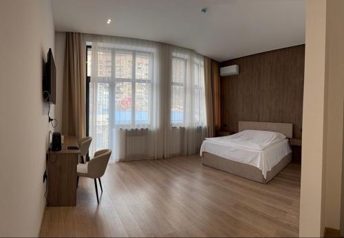 a bedroom with a bed and a desk and a window at Prince Hotel Kapan in Kapan