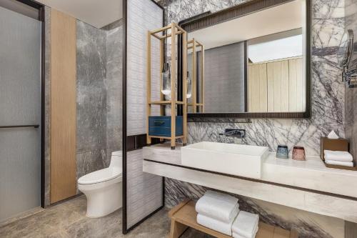 a bathroom with a sink and a toilet at Qingdao Marriott Hotel Jiaozhou in Qingdao