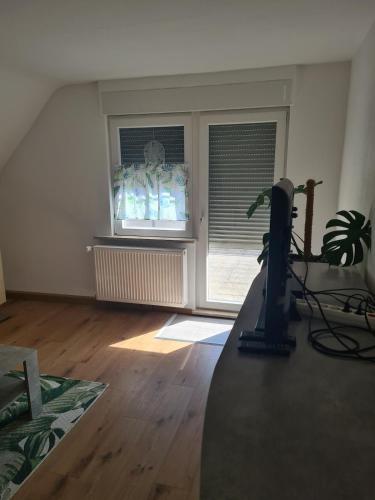 an empty living room with a window and a desk at Monstera Apartment in Groß-Umstadt