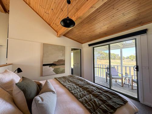a bedroom with a bed and a balcony at Clonmara Country House and Cottages in Port Fairy