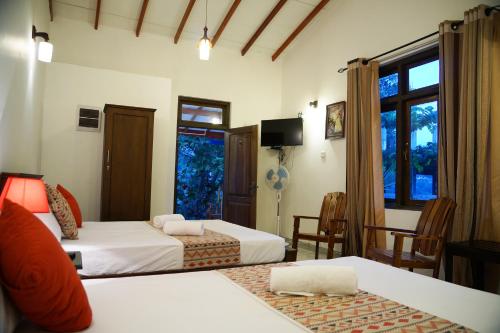 ein Hotelzimmer mit 2 Betten und einem Fenster in der Unterkunft Kandy Moon Hills Hotel in Kandy
