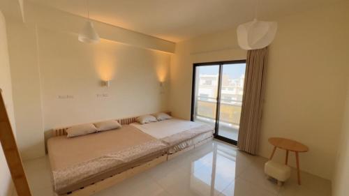 a bedroom with a bed and a large window at Grass in the Wind B&B in Magong